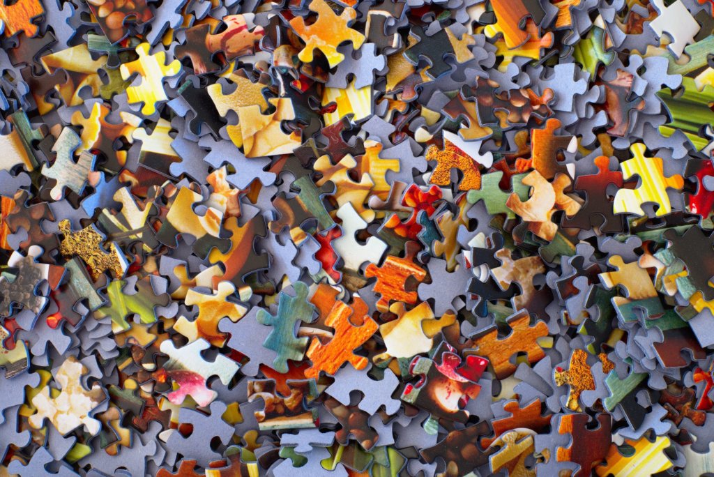 several orange and grey jigsaw puzzle pieces in a pile