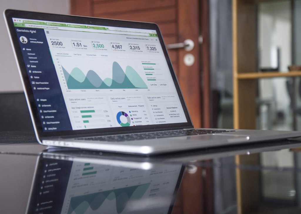 a laptop sitting on a table with a screen pulled up of various abstract charts